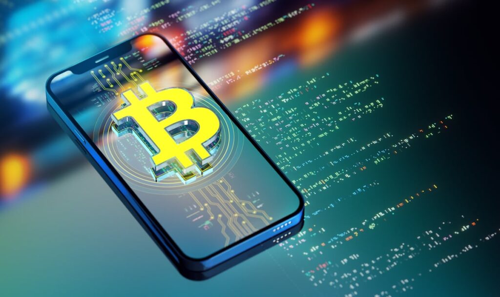 The Bitcoin logo rising up out of a smartphone.