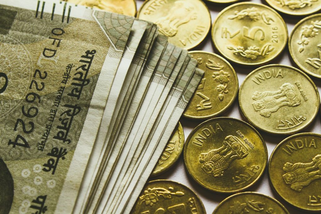 round gold-colored rupee coins and banknotes; money management for founders