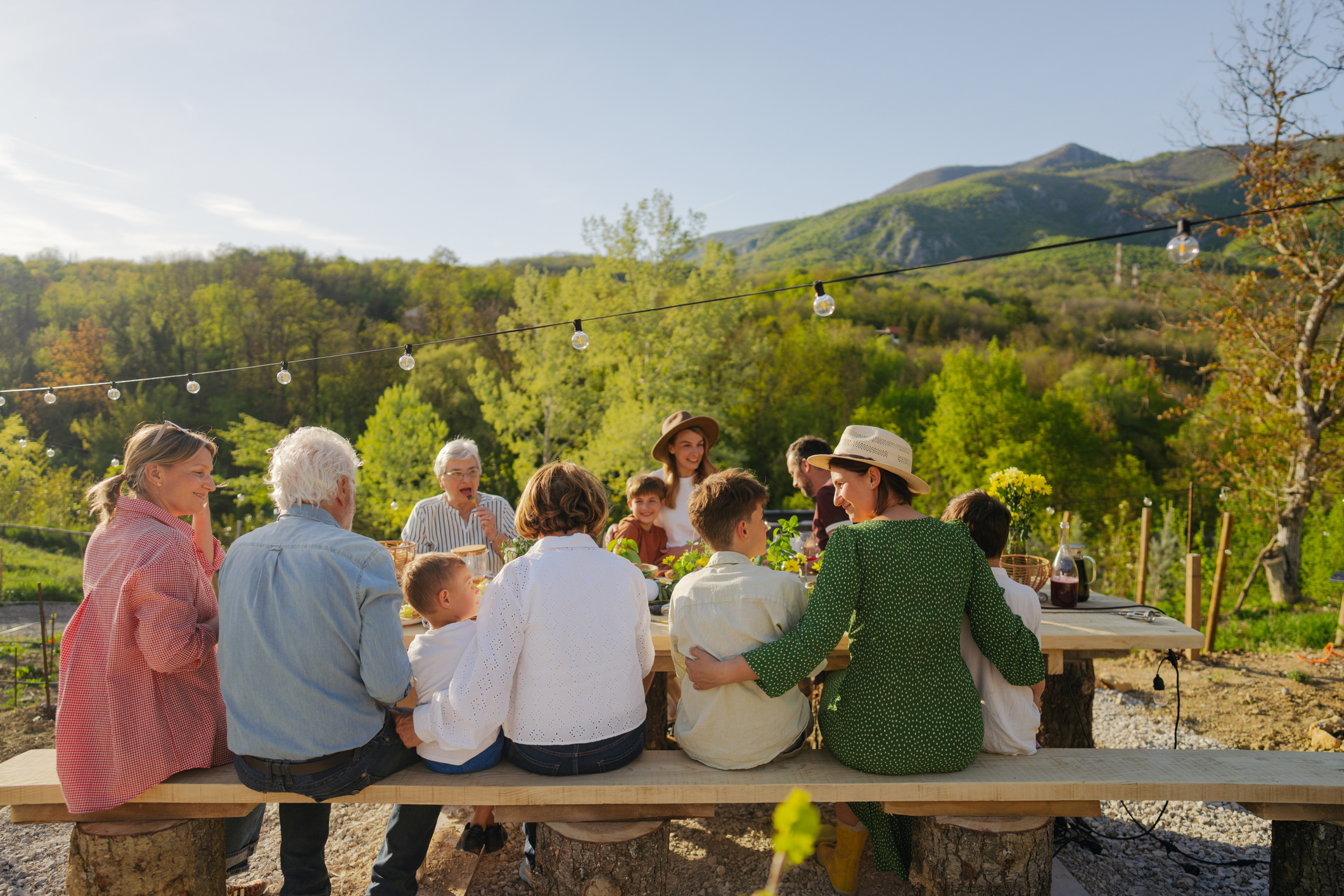 Photo of a multi-generation family having Italian style dinner party, outdoors in their back yard