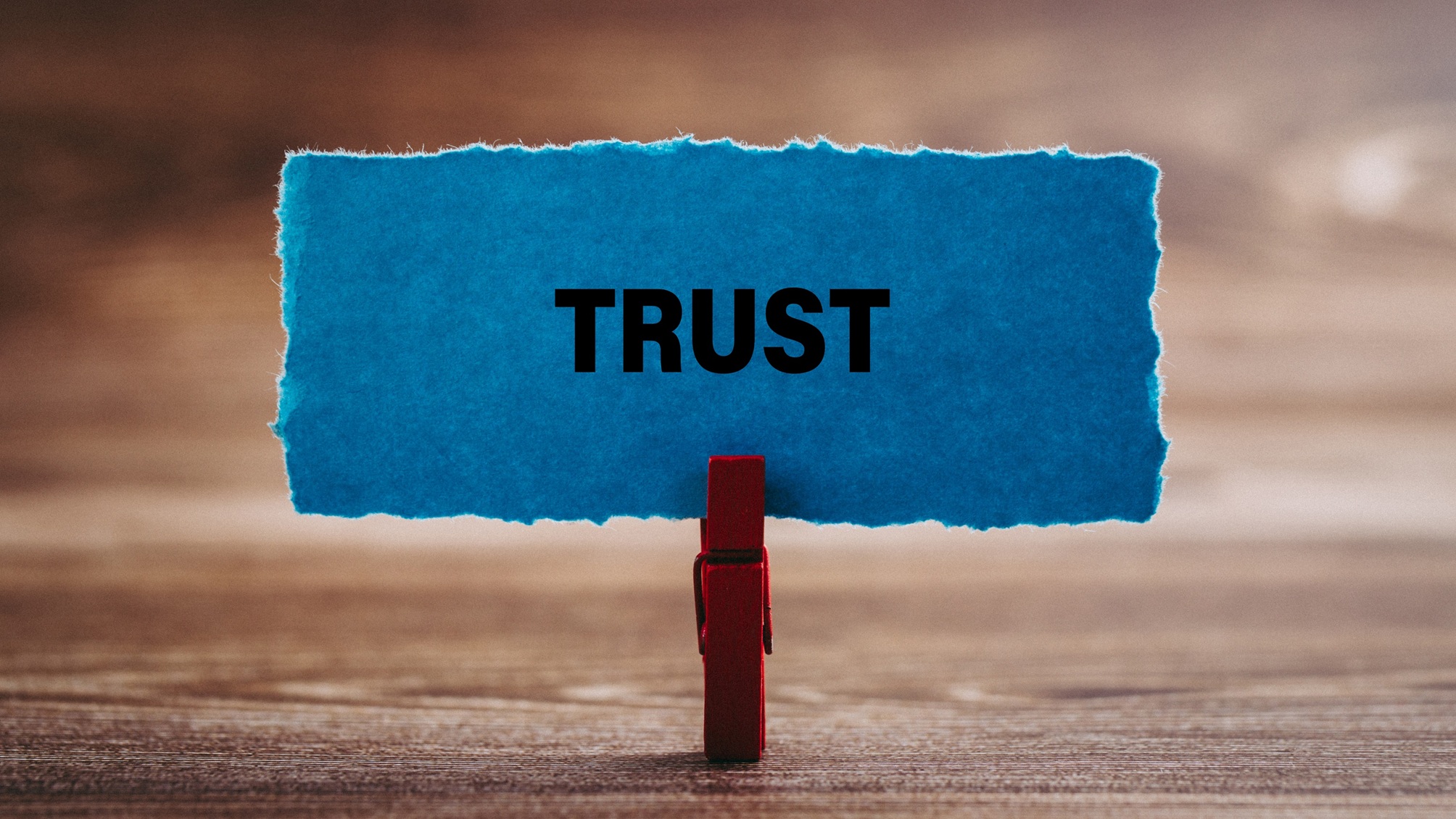 A piece of blue parchment held in a clothespin says the word "trust."