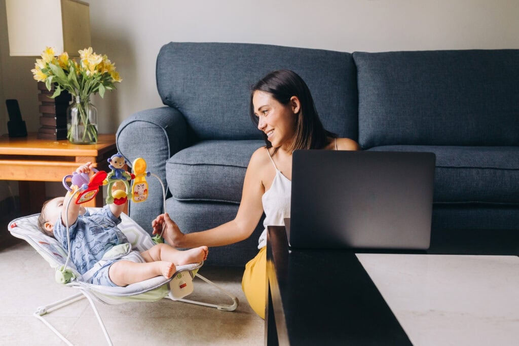 woman taking care of baby while working