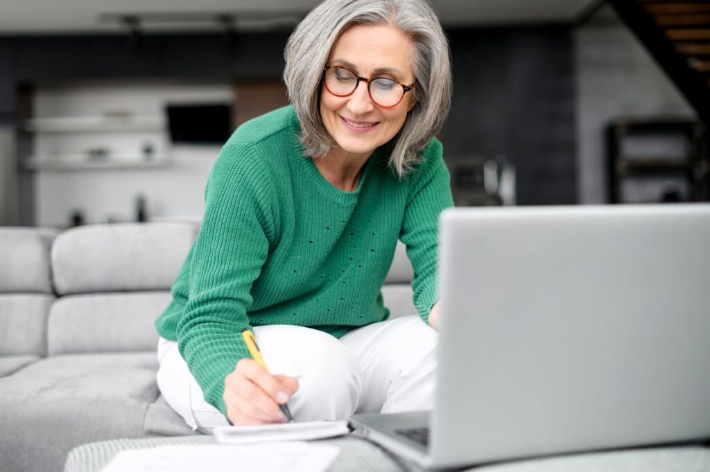 Smiling person writing note in notebook.