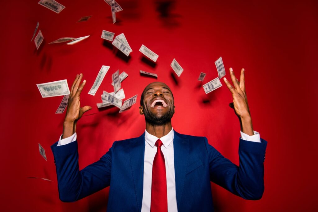 A happy person with money raining down around them.