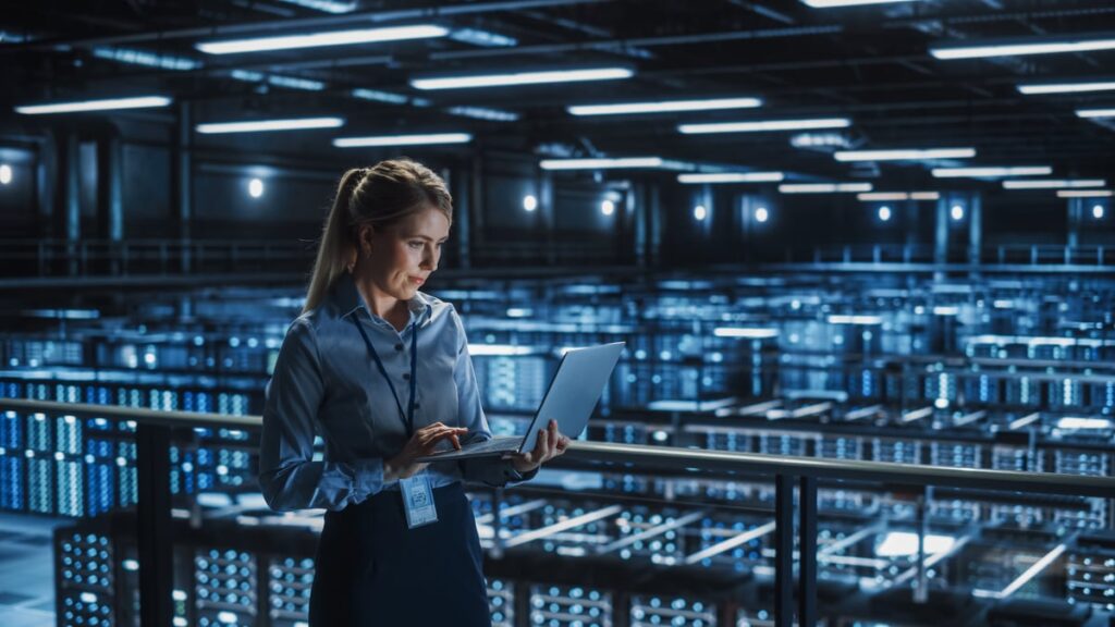 A person is smiling while working in an AI data center.