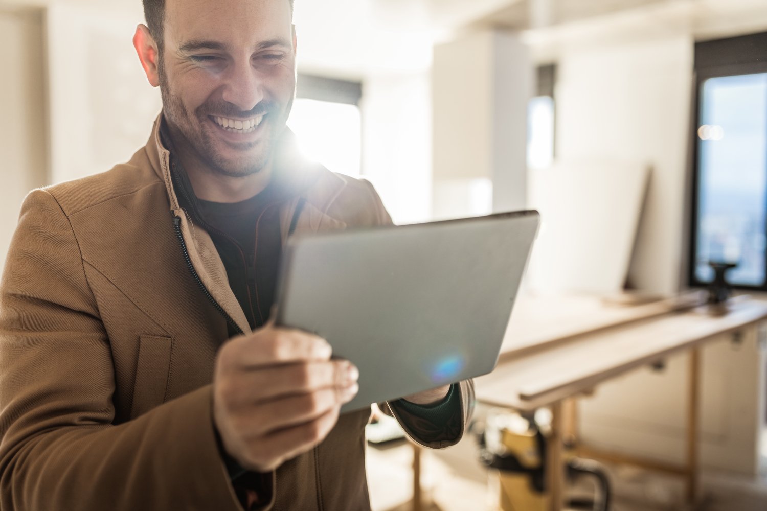 A smiling investor looks at a tablet.