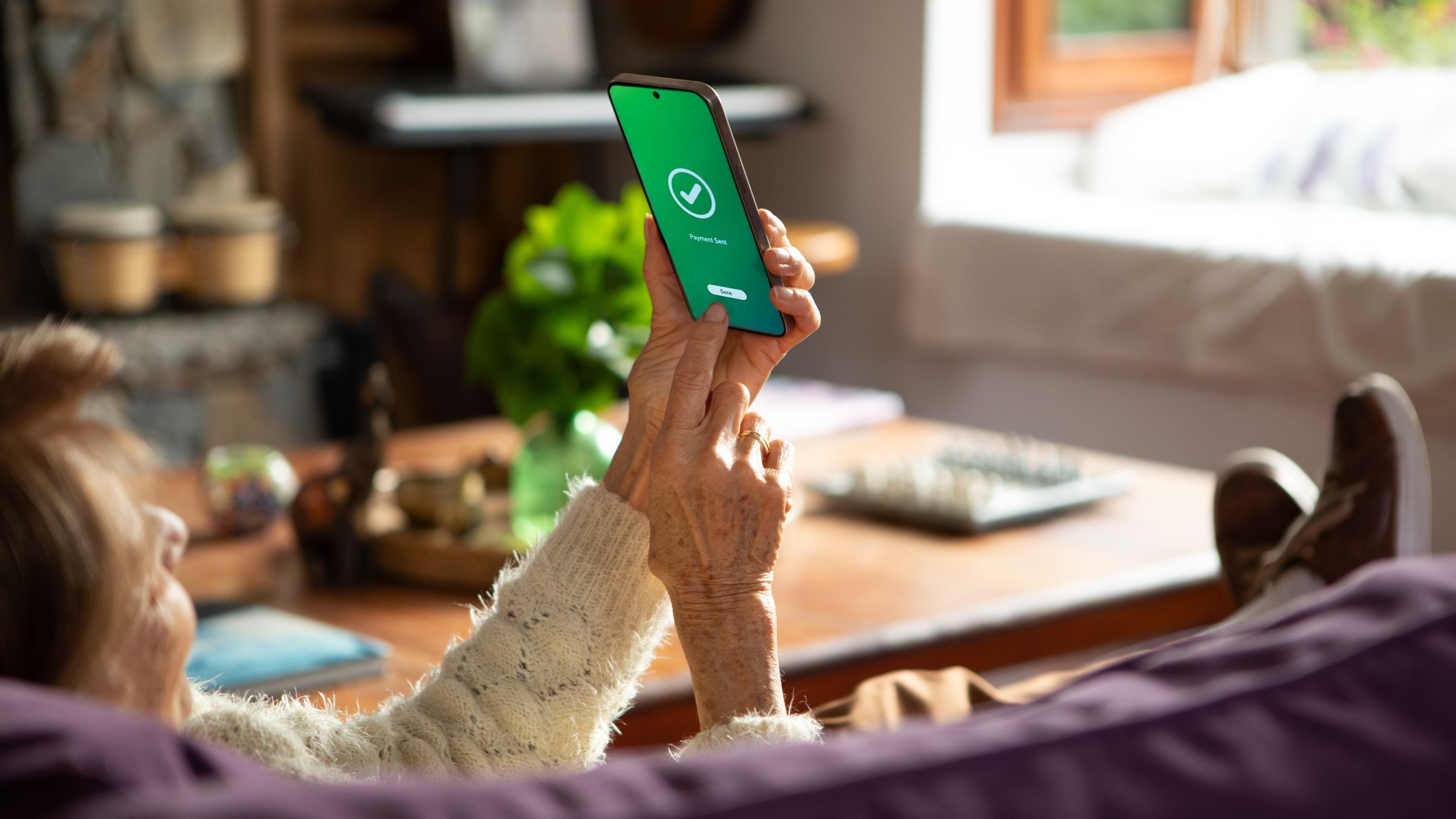 a man sees a notification on his phone about a completed money transfer